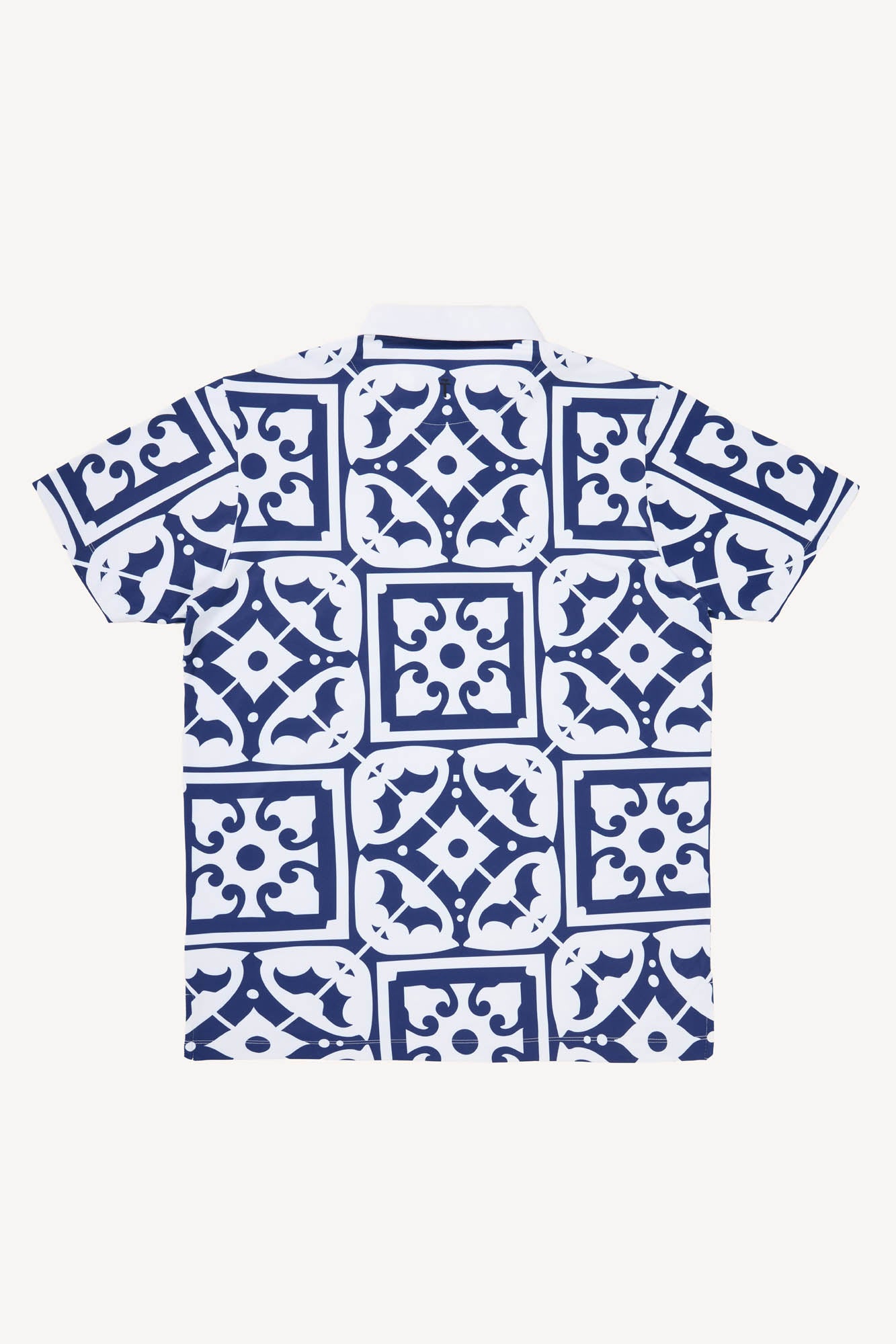 White performance polo golf shirt with blue geometric pattern resembling tiles found on the Iberian peninsula on a white background