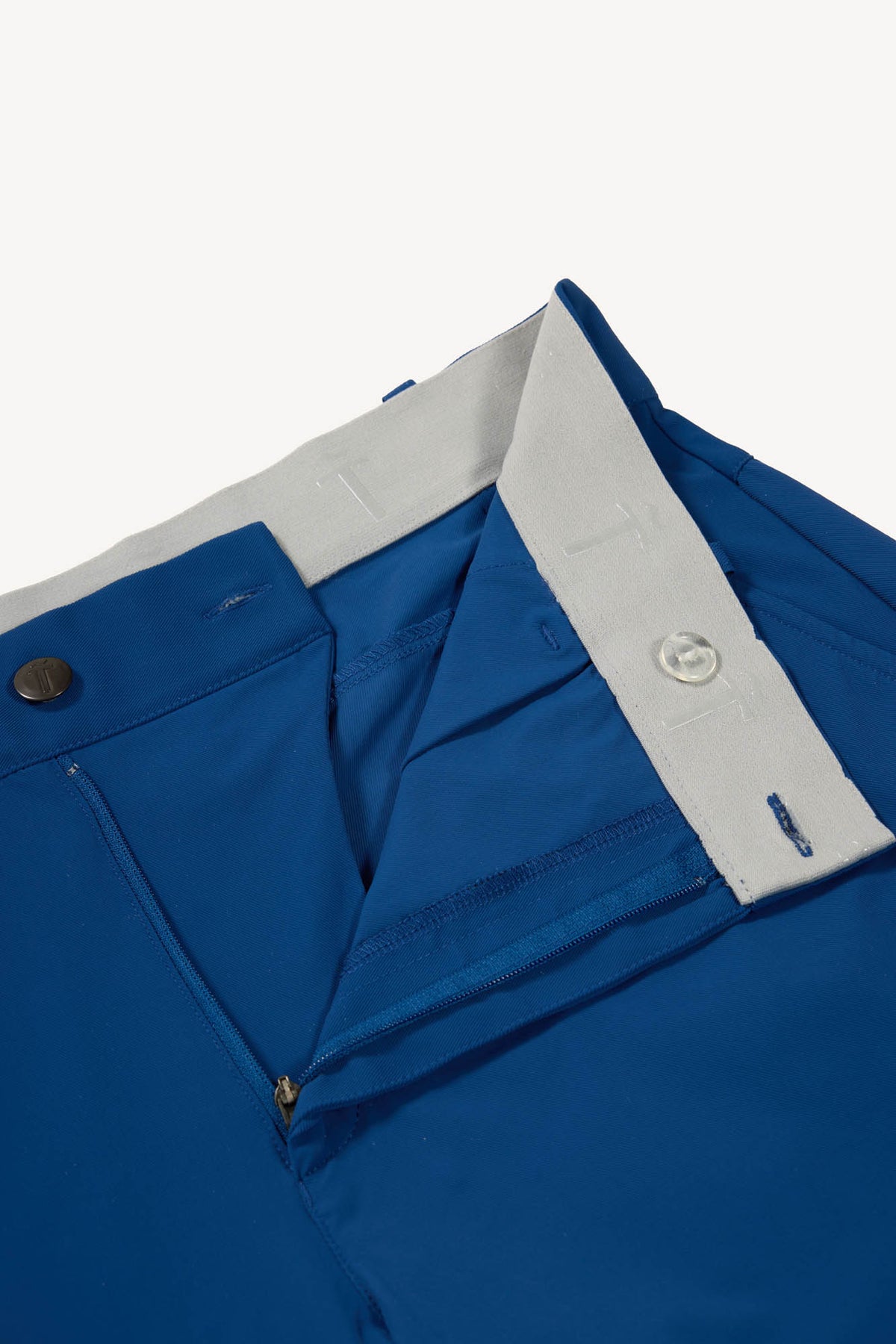 Close-up of blue pants with a gray waistband on a white background