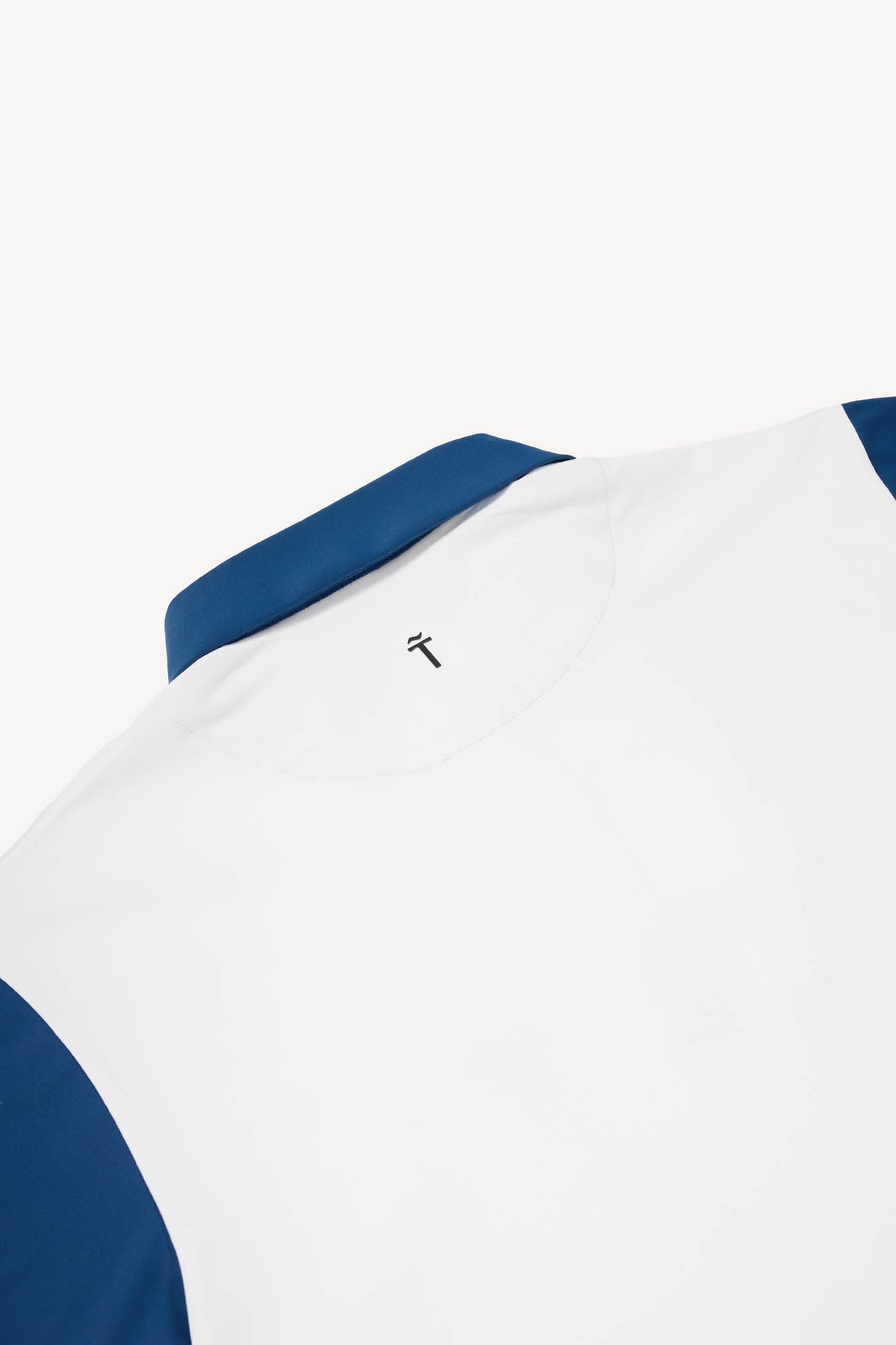 White and blue performance golf polo with blue accents on a white background