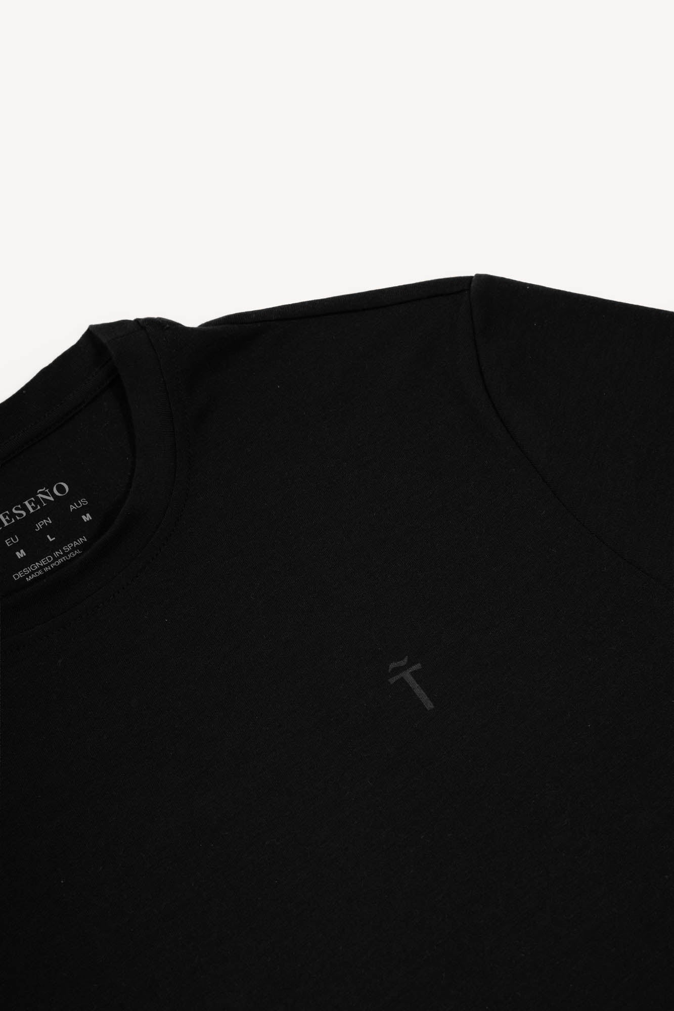 Black t-shirt with a small Treseño logo on the chest against a white background