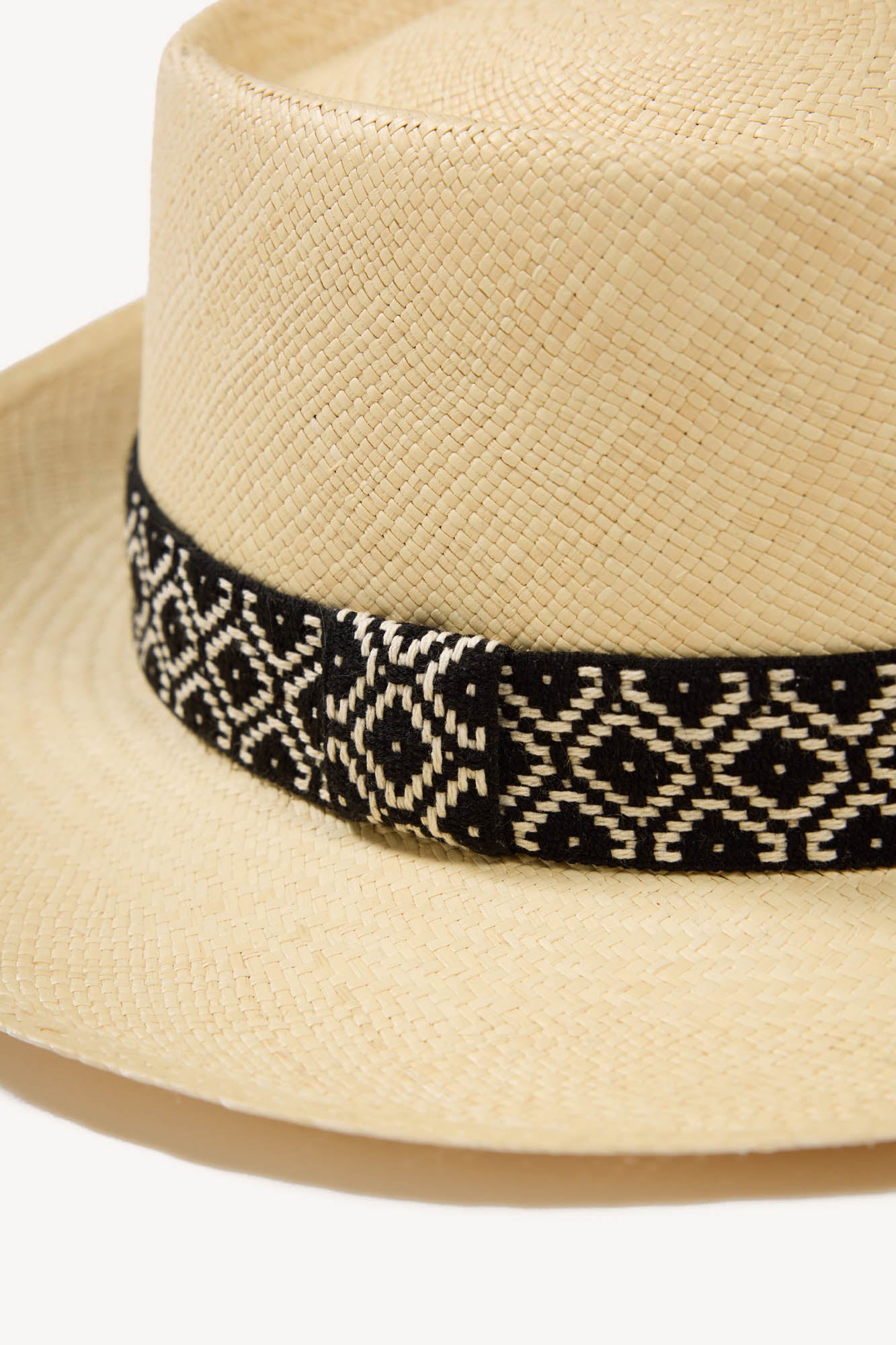luxury handcrafted Panama hat with a black and white patterned band on a white background