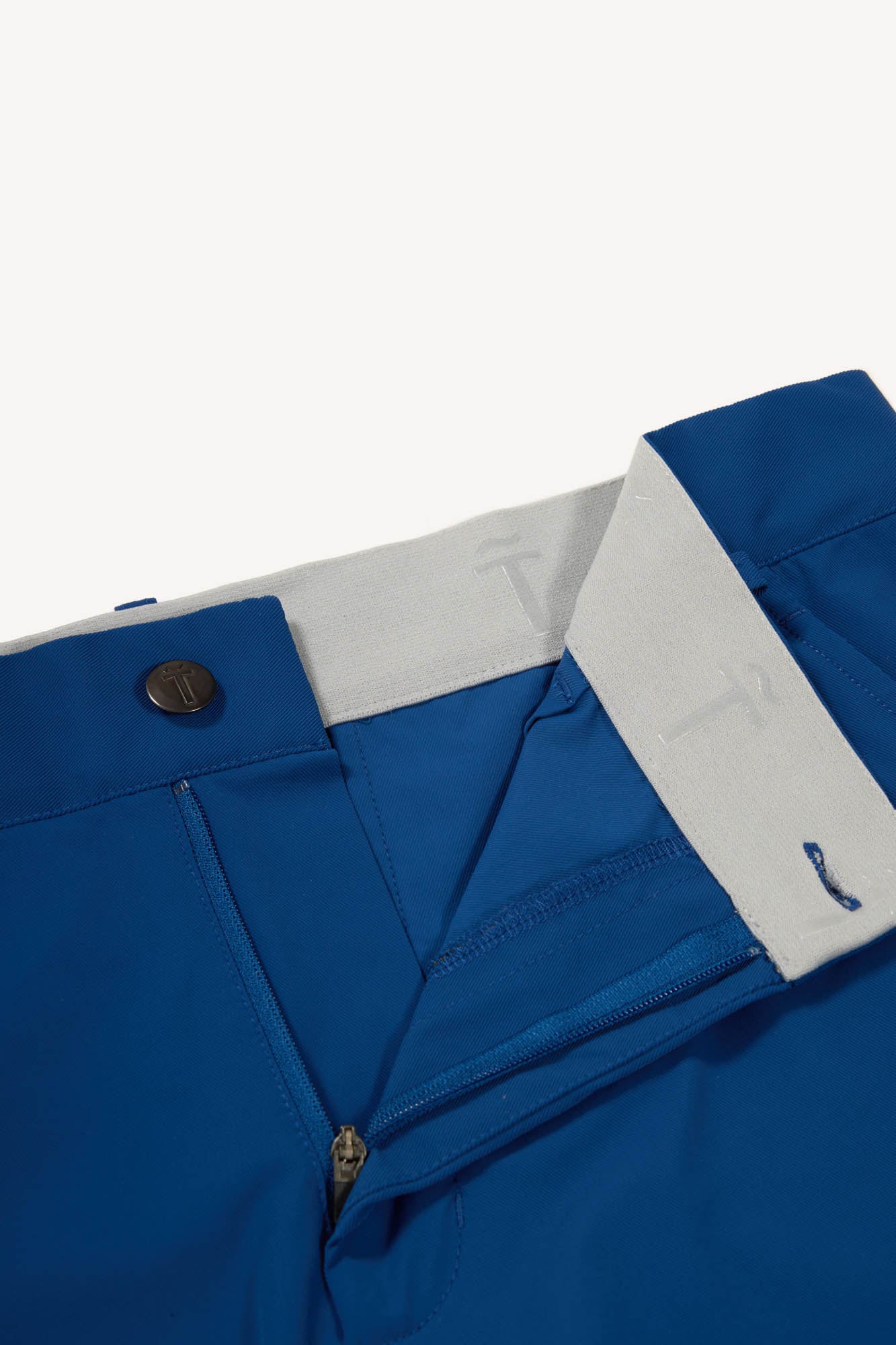 Close-up of blue pants with grey trim on a light gray background