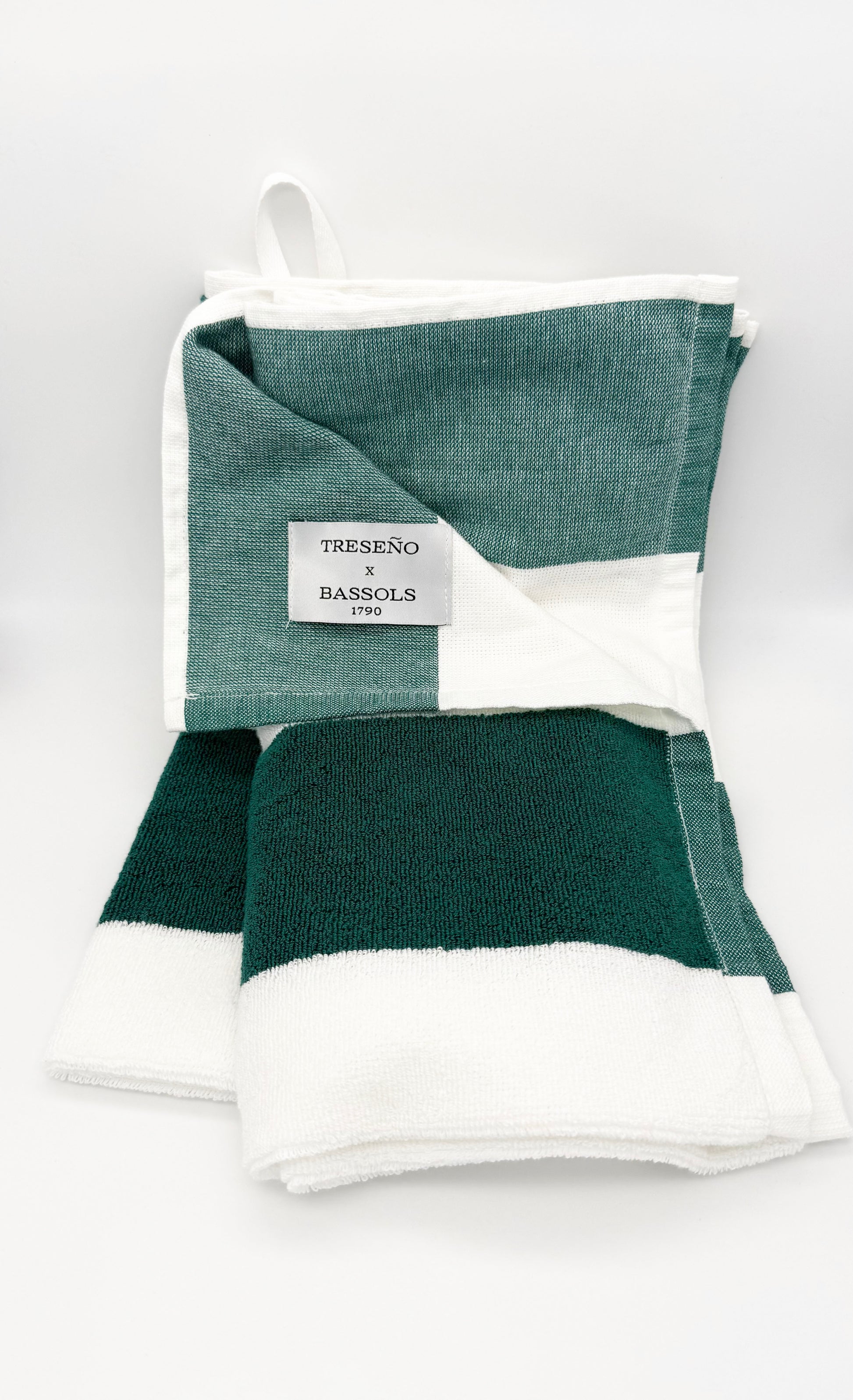 Green and white striped towel with a brand label on a white background