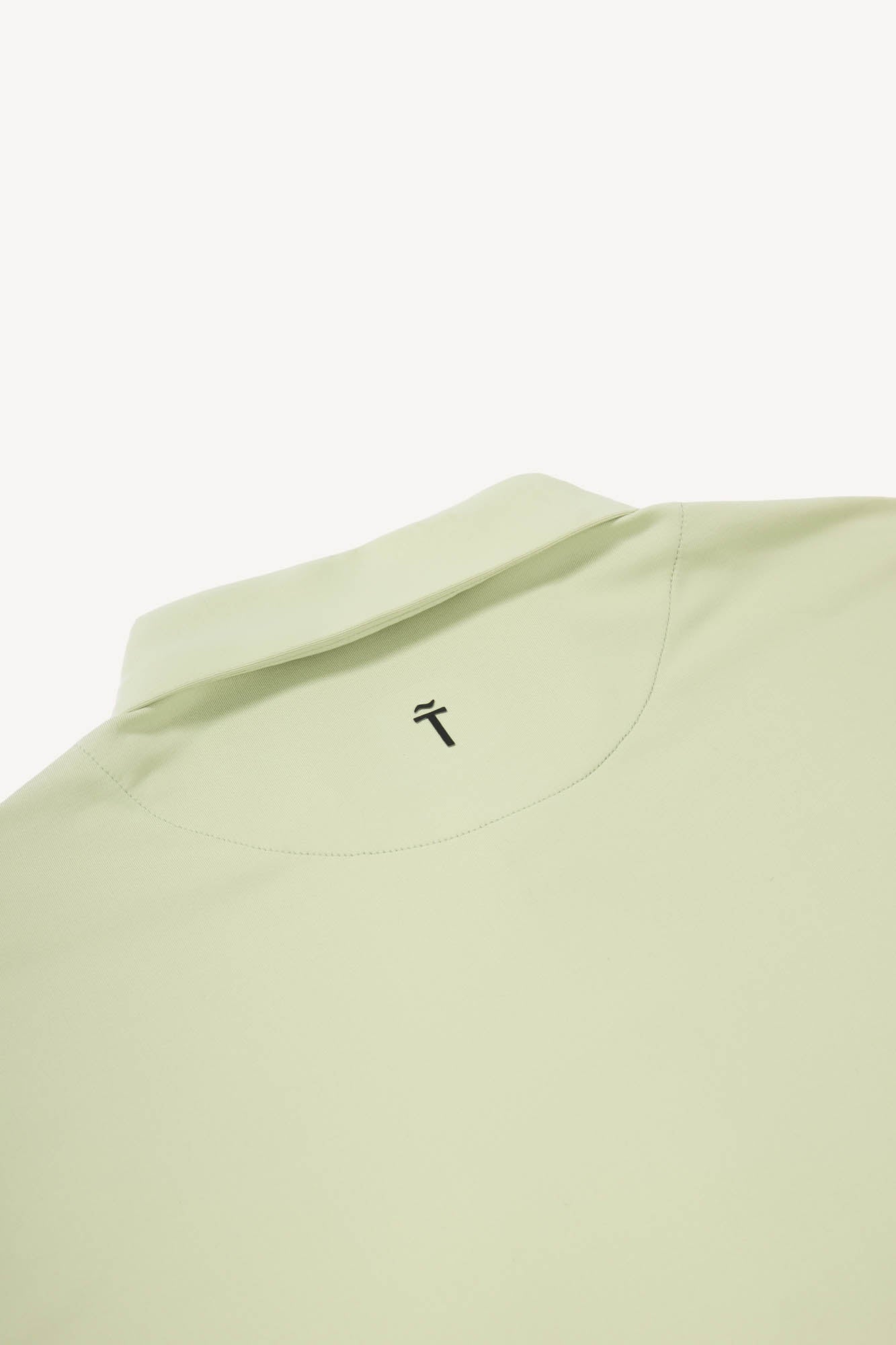 Light green t-shirt with a small black Treseño logo on a white background
