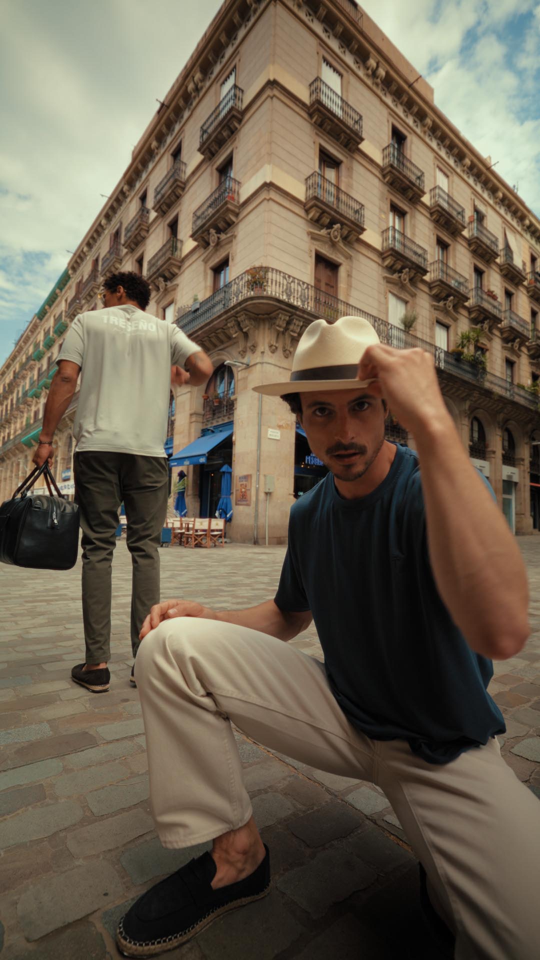 Two men in an urban setting with a building in the background