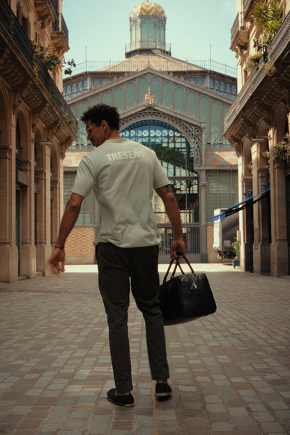 Man walking through an architectural street with a large building in the background