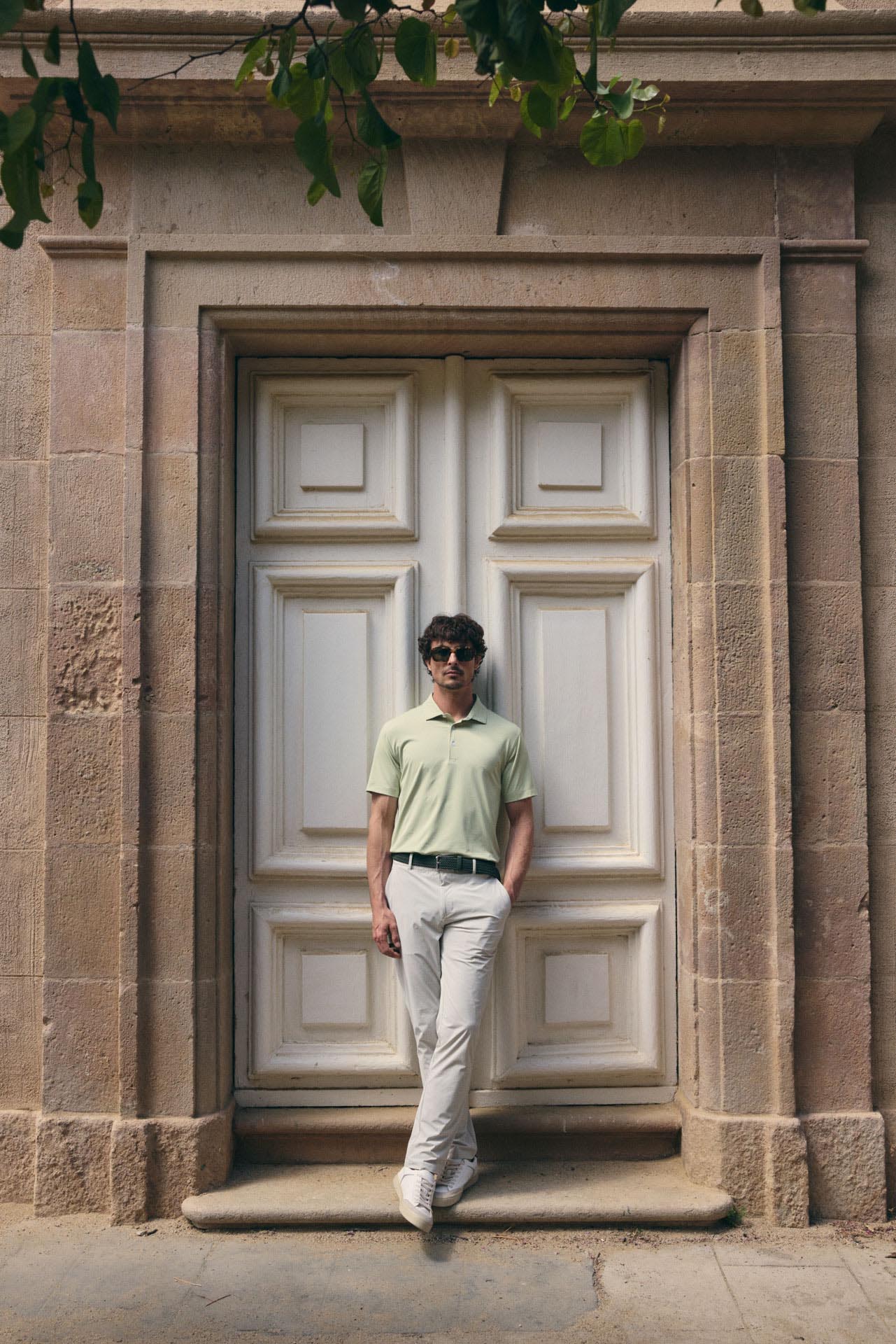 Man standing in front of a large stone door with architectural details