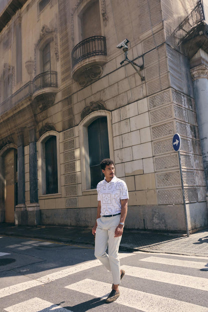 Man walking on a street in an urban setting with a building in the background