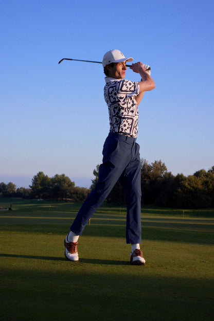 Person playing golf on a green field with trees in the background
