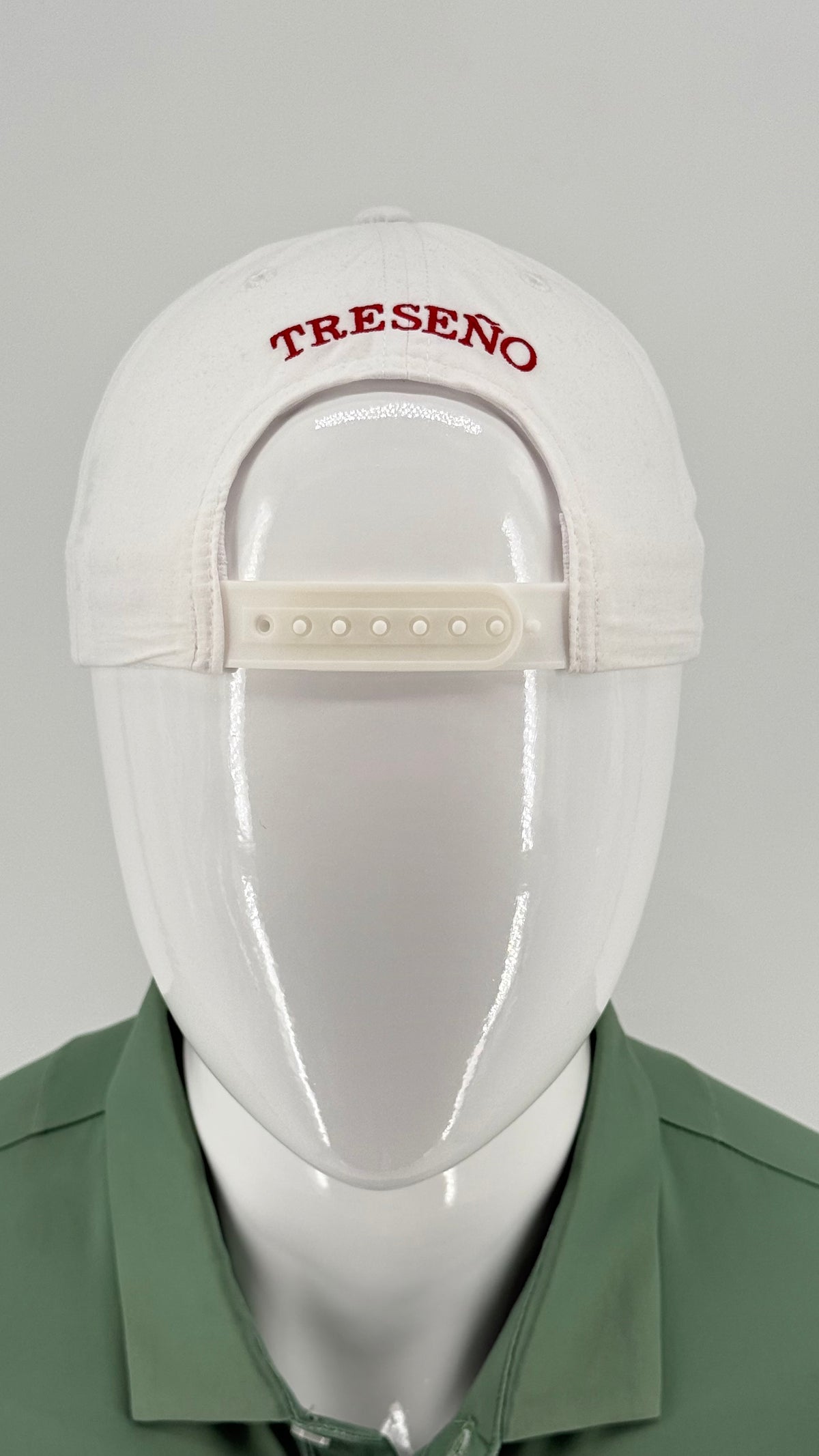 A white baseball cap with 'TRESENO' embroidered in red on the front, displayed on a white mannequin head wearing a green collared shirt against a light gray background.