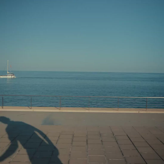 Man in luxury gradient blue golf polo by the ocean