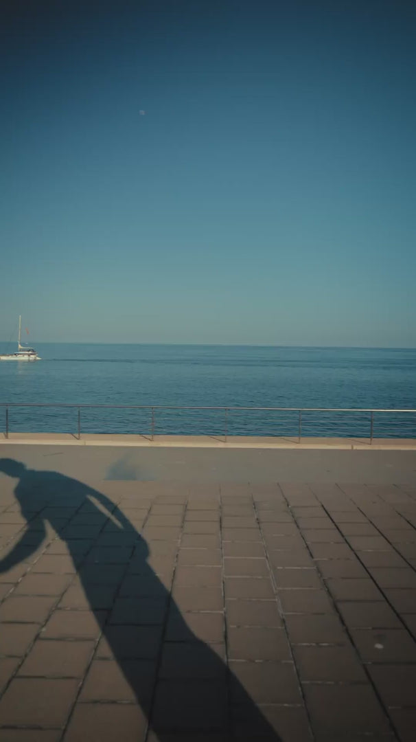 Man in luxury gradient blue golf polo by the ocean